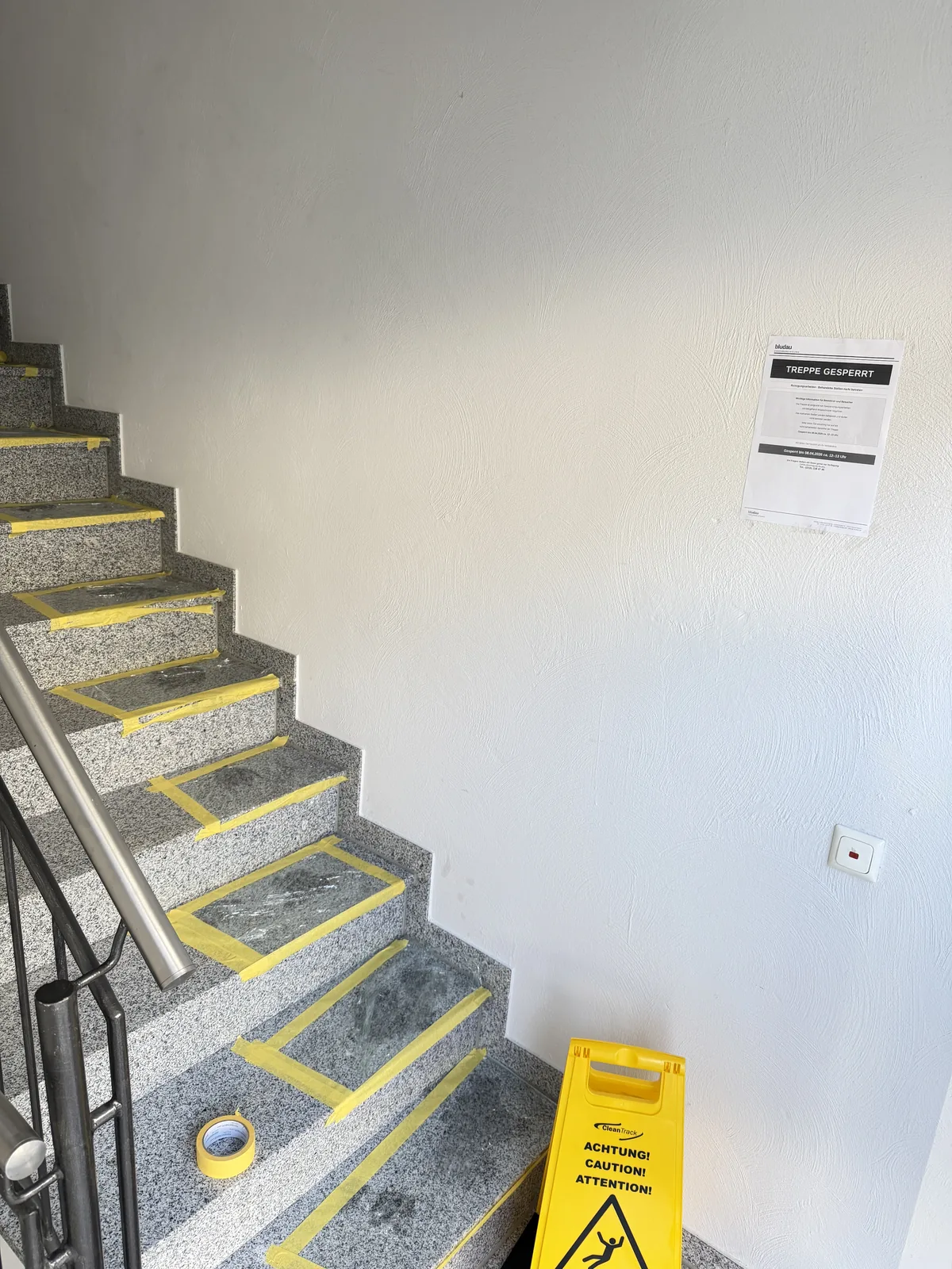 Treppenhaus mit Warntafel Achtung Rutschgefahr während der Ölfleck-Behandlung mit Saugpaste