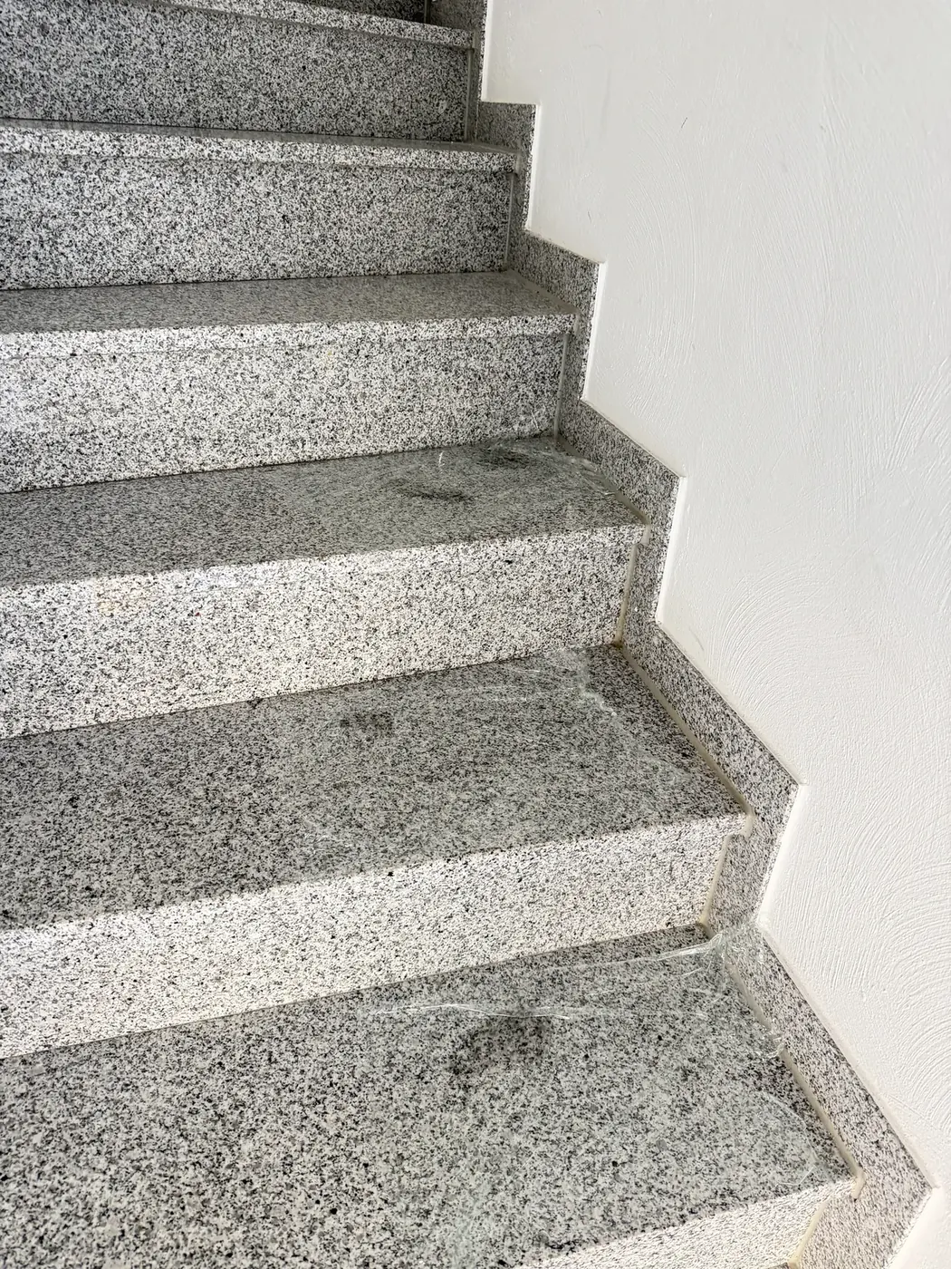 Motorölflecken auf Granit-Treppenstufen vor und nach der Behandlung mit Öl-Saugpaste